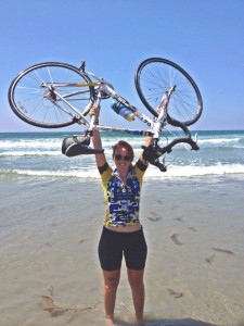 SGA President Charlotte Ridgeway lifts her bike in celebration of reaching San Diego, the destination of her summer-long ride. 