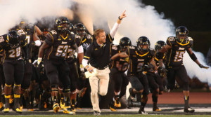 Head coach Rob Ambrose leads the Tigers onto the field for Saturday's home opener against Delaware State. 