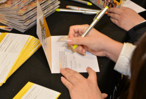 A student signs a donor thank you card 