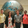 Four TU Library of Congress GIS interns in front of a topographical globe.